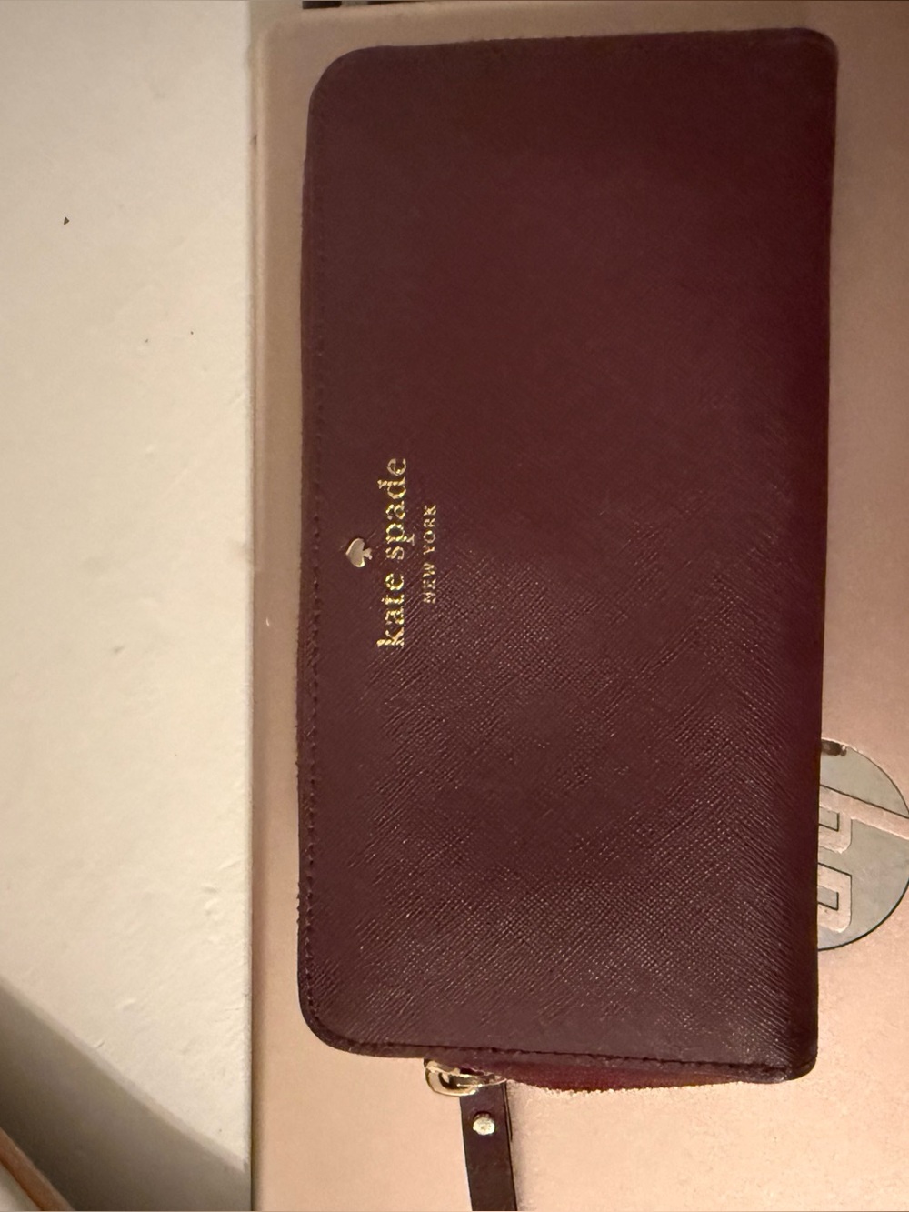 kate spade burgundy leather zip-around wallet with gold logo